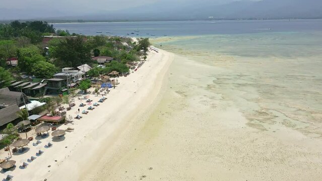 Aerial view of sunshades on a tropical beach at low tide (Gili Air, Indonesia)