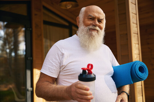 Elderly man left the house for morning exercises with karimat