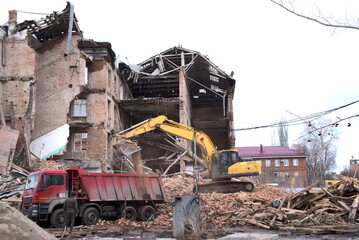 dismantling of an old brick building with an excavator. the concept of urban renewal.