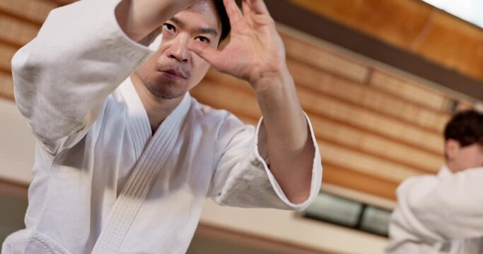 Black belt students, karate or sensei teaching martial arts in dojo for aikido, movement or self defense. Japanese combat, talking or people in training for fighting, education or learning in class