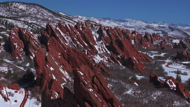 March winter morning snow stunning Roxborough State Park Littleton Colorado aerial drone over sharp jagged dramatic red rock formations Denver foothills front range landscape blue sky forward slowly