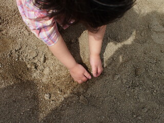 砂場で遊ぶ2歳の女の子