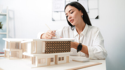 Closeup portrait image of professional young beautiful engineer architect using triangular scale measures house model with focusing at modern office. Business creative design concept. Immaculate. - obrazy, fototapety, plakaty