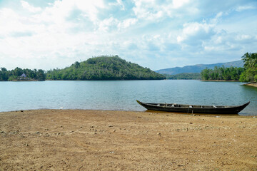Serene view of a Canoe resting on the shores of Mayan Quay,  Amboori,  Neyyar Dam