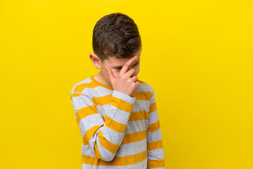 Little caucasian boy isolated on yellow background laughing
