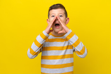 Little caucasian boy isolated on yellow background shouting and announcing something