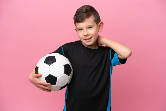 Little caucasian football player boy isolated on pink background laughing