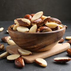 wooden bowl of tasty brazil nuts on white background