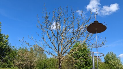 Wind chimes in the park against the blue sky with white clouds