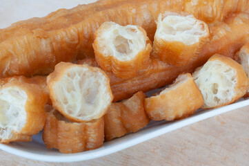 Close up of cut cakoi or youtiao cake on white plate. Asian food concept
