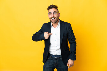 Businessman over isolated yellow background with surprise facial expression