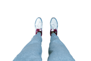 A person's legs in gray sweatpants and white sneakers with red accents, isolated on a white background, ideal for a fashion or sports layout concept
