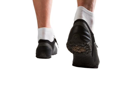 A person walking, with focus on the black sneakers, against a white background, depicting movement or exercise