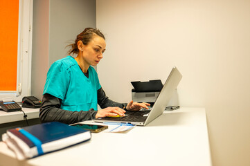 A doctor working at a computer in her office.