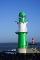 Leuchtturm an der Hafeneinfahrt in Rostock-Warnemuende - obrazy, fototapety, plakaty