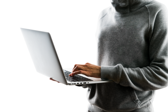 A person in a gray hoodie using a laptop, photographed against a white background, illustrating the concept of remote work or technology use - Powered by Adobe