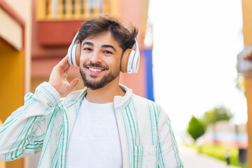 Handsome Arab man at outdoors listening music