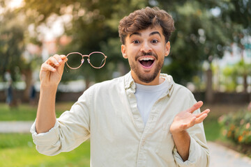 Young Arabian handsome man with glasses at outdoors with shocked facial expression