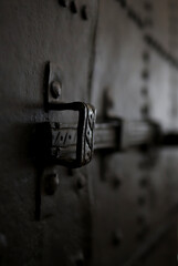 antique metal bolt on an iron door in a gloomy background