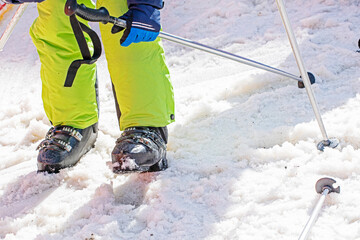 skier puts on ski boots on a snowy slope. active holiday with family