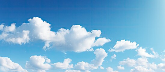 Vast expanse of lush green grass stretches under a scattered array of fluffy white clouds in the clear blue sky