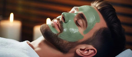 Zelfklevend Fotobehang Spa A man is seen relaxing in a spa salon while indulging in a rejuvenating facial treatment with a luxurious cucumber mask, creating a calm and peaceful ambiance
