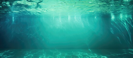 An underwater image shows a deep turquoise swimming pool devoid of water, capturing the serene beauty beneath the surface