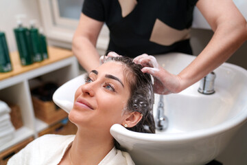 A woman enjoys a calming shampoo session at a hair treatment clinic.