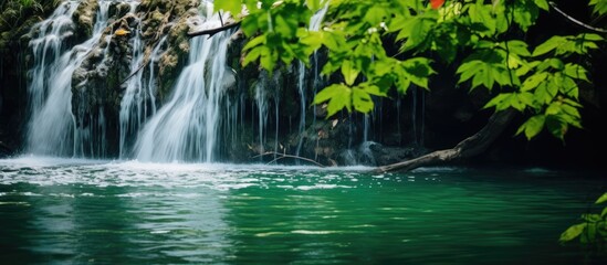 A picturesque waterfall in the midst of a lush forest with colorful leaves and soft emerald green water, creating a serene and relaxing atmosphere for outdoor activities