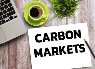 Business quotes, CARBON MARKETS on notebook or paper in office desk