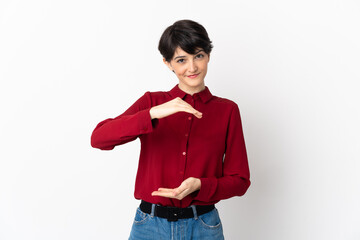Woman with short hair isolated on white background holding copyspace imaginary on the palm to...