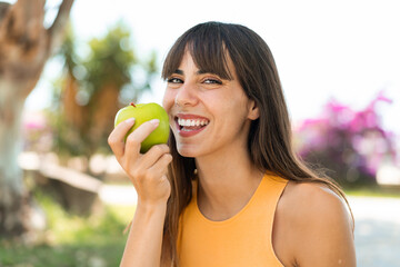 Young woman at outdoors holding an apple - 771330364
