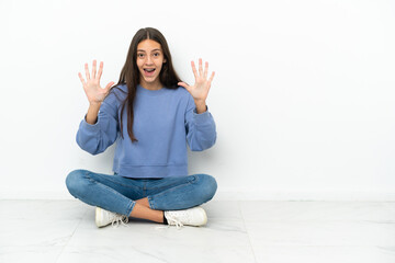 Young French girl sitting on the floor counting ten with fingers