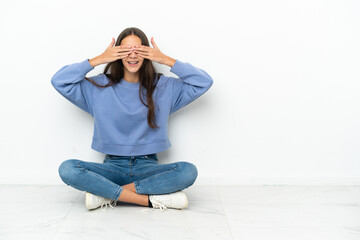 Young French girl sitting on the floor covering eyes by hands - obrazy, fototapety, plakaty