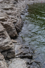 river water, surf, rocky shore, top view of clear reservoir water