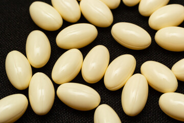 Fototapeta na wymiar White capsules, pills on a black background. Medicine, healthcare concept. Range of pharmaceutical drugs