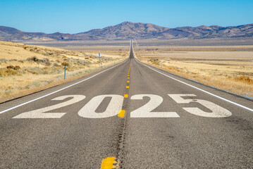 Long straight highway in the desert with 2025 painted on the asphalt