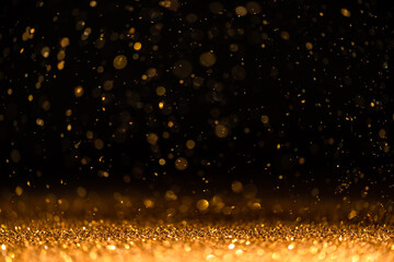 gold sequins fall on a black background
