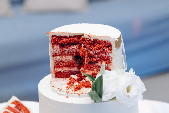 sliced white wedding cake with red sponge cake
