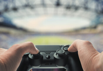 Hands Holding Game Controller with Stadium Background