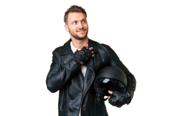 Young caucasian man with a motorcycle helmet over isolated chroma key background looking up while smiling