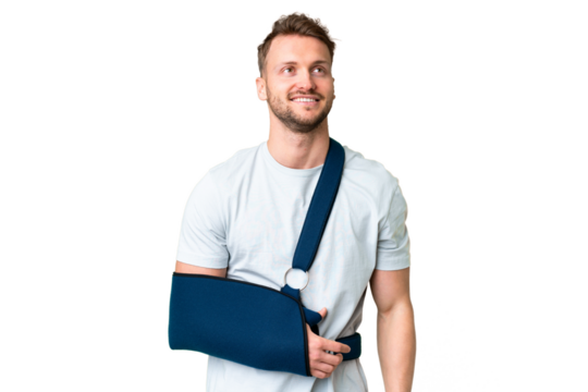 Young caucasian man with broken arm and wearing a sling over isolated chroma key background thinking an idea while looking up