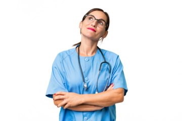 Middle-aged nurse woman over isolated background looking up while smiling
