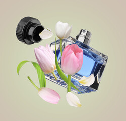 Bottle of perfume and tulips in air on beige background