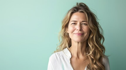Beautiful middle-aged woman on a plain background. Model for advertising cosmetics. - obrazy, fototapety, plakaty