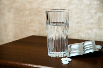 Pills and a glass of water. Health care and illness concept.