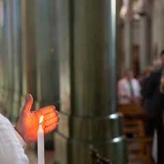 solemn church ceremony with lit candle in focus