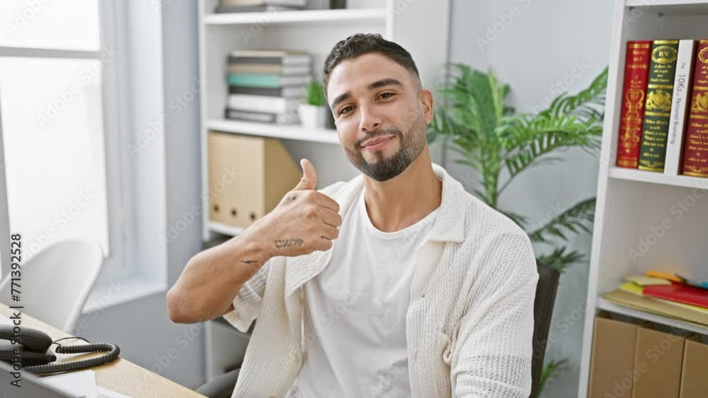 Canvas Prints Young arab businessman, sitting in the office showing off a confident smile and a thumbs-up, approval sign, radiating positivity and happiness