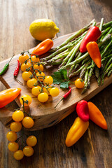 branch with yellow cherry tomatoes, asparagus, hot peppers and Brussels sprouts on a wooden board
- 771395171