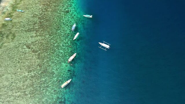 Top down aerial view of snorkel boats on the edge of a fringing coral reef